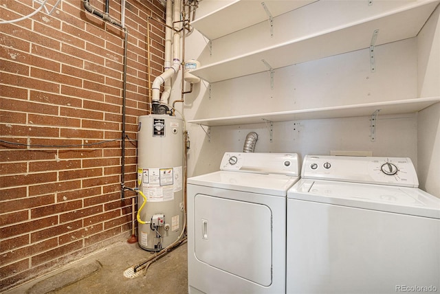 4258 Tennyson St Unit 104, Denver, CO 80212 - laundry room featuring gas water heater, washing machine and dryer, and brick wall