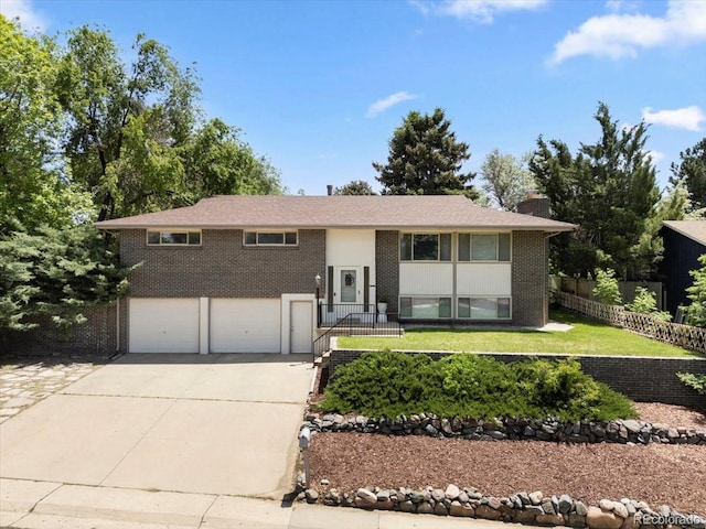 2502 S Lima St, Aurora, CO 80014 - raised ranch with concrete driveway, a chimney, an attached garage, and brick siding