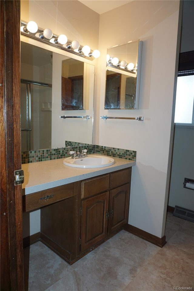 4130 Aspen Ln, Evergreen, CO 80439 - full bathroom with backsplash, baseboards, vanity, and a shower with door