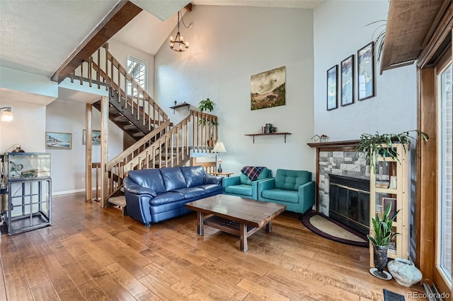 10806 W Evans Ave Unit 5, Lakewood, CO 80227 - living room featuring high vaulted ceiling, stairway, a stone fireplace, wood-type flooring, and beamed ceiling