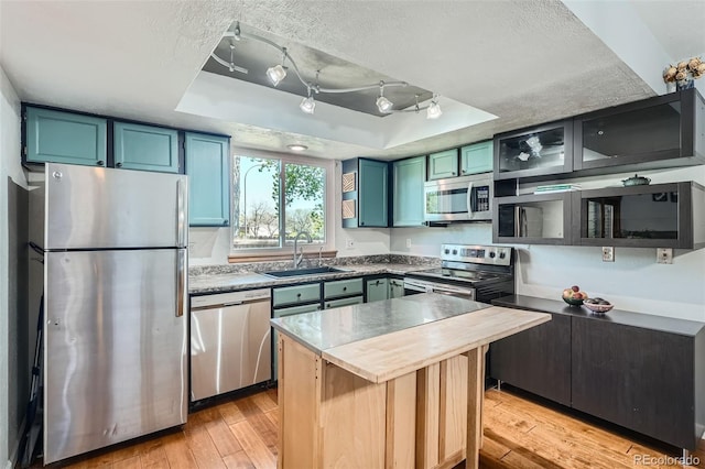 10806 W Evans Ave Unit 5, Lakewood, CO 80227 - kitchen featuring appliances with stainless steel finishes, a sink, a raised ceiling, light wood-style floors, and a textured ceiling