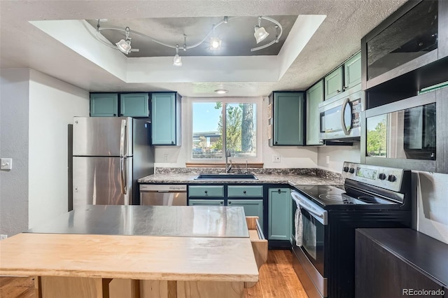 10806 W Evans Ave Unit 5, Lakewood, CO 80227 - kitchen featuring appliances with stainless steel finishes, a sink, a raised ceiling, and green cabinets