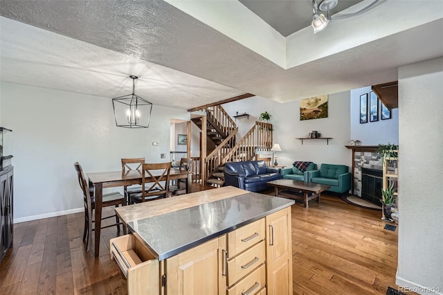 10806 W Evans Ave Unit 5, Lakewood, CO 80227 - kitchen featuring light brown cabinetry, dark wood-type flooring, open floor plan, a fireplace, and baseboards