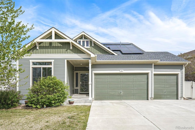 4873 Cathay Ct, Denver, CO 80249 - view of front of property with concrete driveway, board and batten siding, an attached garage, and roof mounted solar panels