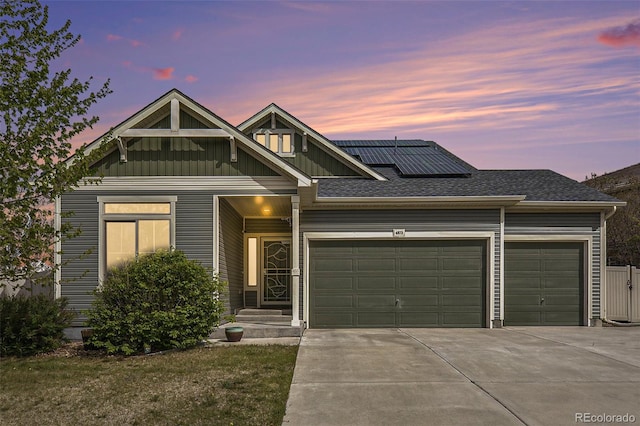 4873 Cathay Ct, Denver, CO 80249 - view of front of house with an attached garage, concrete driveway, solar panels, and board and batten siding