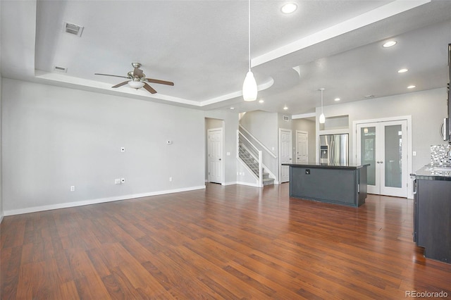 4873 Cathay Ct, Denver, CO 80249 - unfurnished living room with ceiling fan, a tray ceiling, stairs, dark wood-type flooring, and baseboards