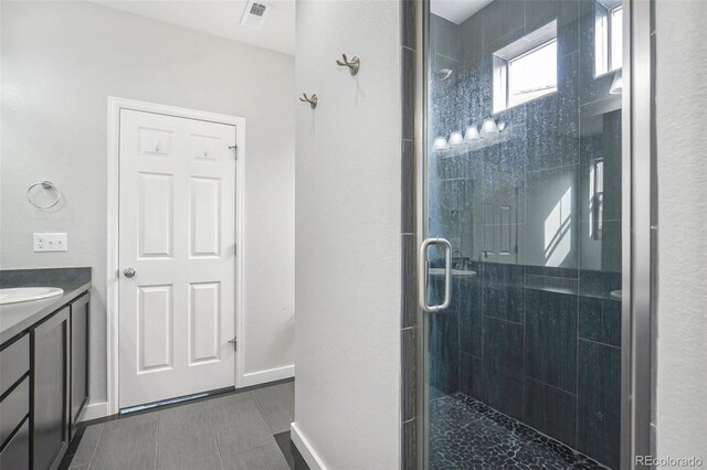 4873 Cathay Ct, Denver, CO 80249 - full bathroom with vanity, visible vents, baseboards, and a stall shower