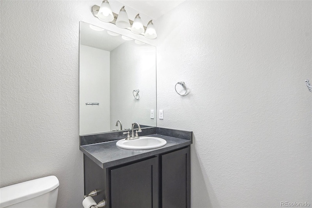 4873 Cathay Ct, Denver, CO 80249 - bathroom with toilet, vanity, and a textured wall