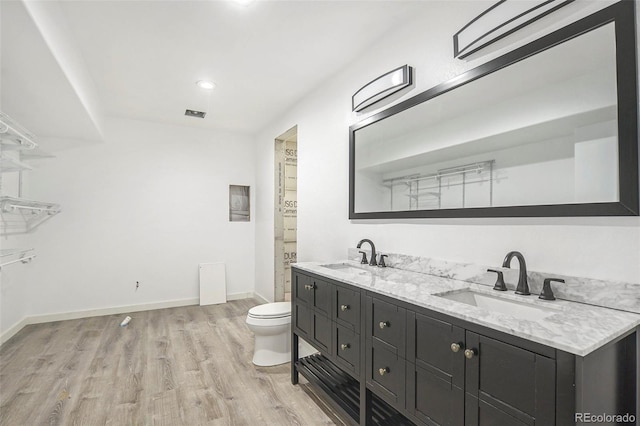 4873 Cathay Ct, Denver, CO 80249 - bathroom featuring wood finished floors, toilet, baseboards, double vanity, and recessed lighting