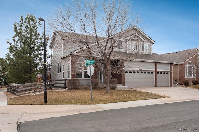 view of front facade with concrete driveway, brick siding, fence, and a front lawn