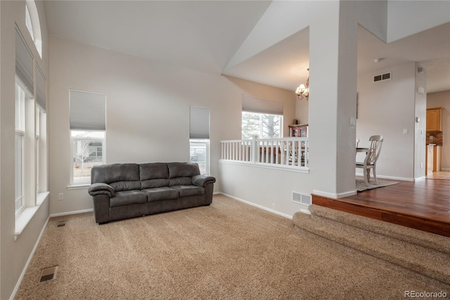 living area with a chandelier, carpet floors, and visible vents