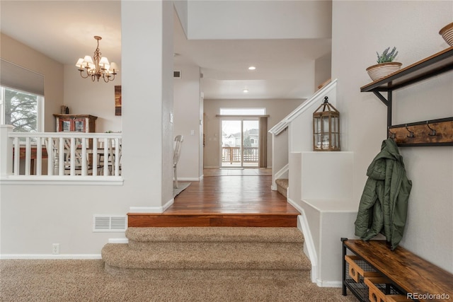 stairs with a chandelier, recessed lighting, visible vents, and baseboards