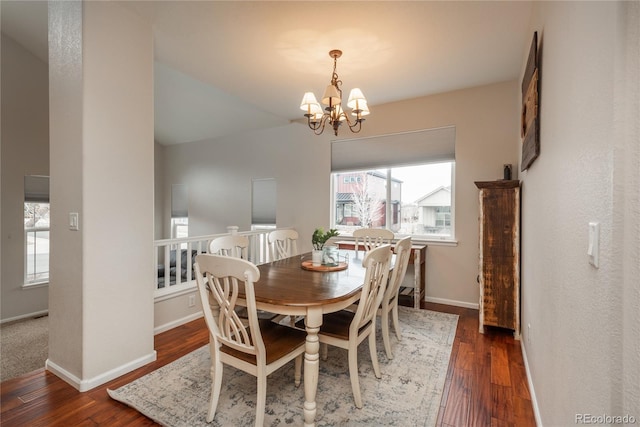 dining area featuring hardwood / wood-style flooring, baseboards, and a notable chandelier