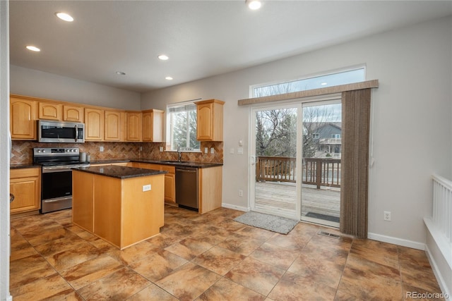 kitchen with stainless steel appliances, dark countertops, visible vents, backsplash, and a sink