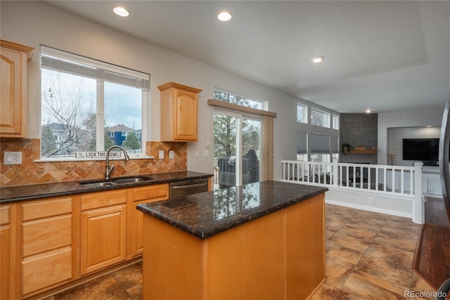 kitchen featuring backsplash, plenty of natural light, a sink, and a center island