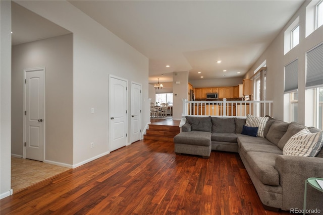 living room featuring recessed lighting, wood finished floors, baseboards, and an inviting chandelier