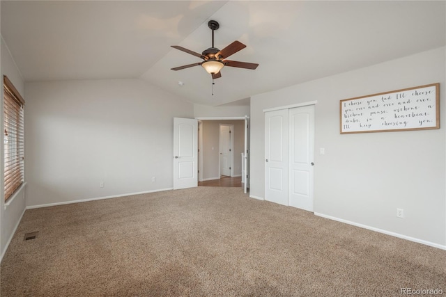 unfurnished bedroom with carpet floors, a closet, visible vents, vaulted ceiling, and ceiling fan