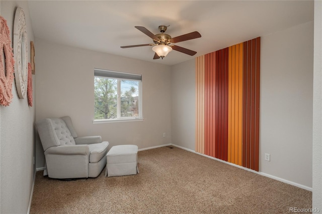 sitting room with baseboards, a ceiling fan, and carpet flooring