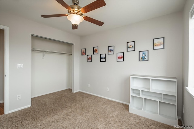 unfurnished bedroom with a closet, carpet flooring, a ceiling fan, and baseboards