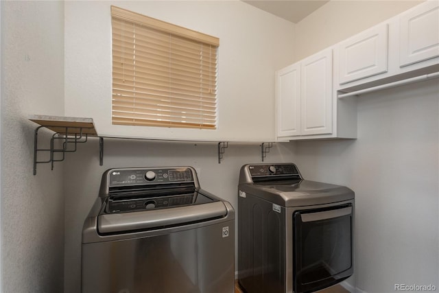 washroom featuring separate washer and dryer and cabinet space