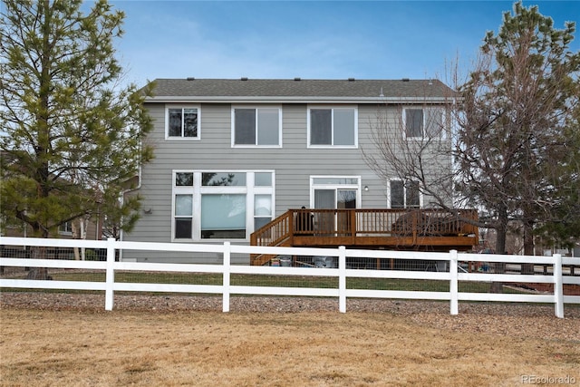 rear view of house with fence and a wooden deck