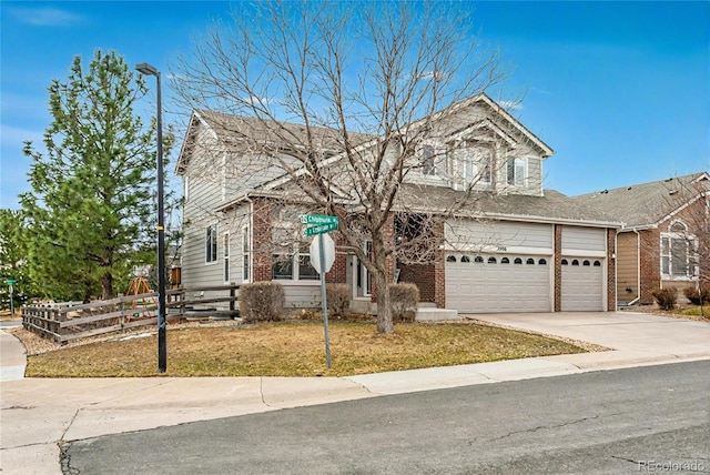 traditional home with a garage, fence, concrete driveway, a front lawn, and brick siding
