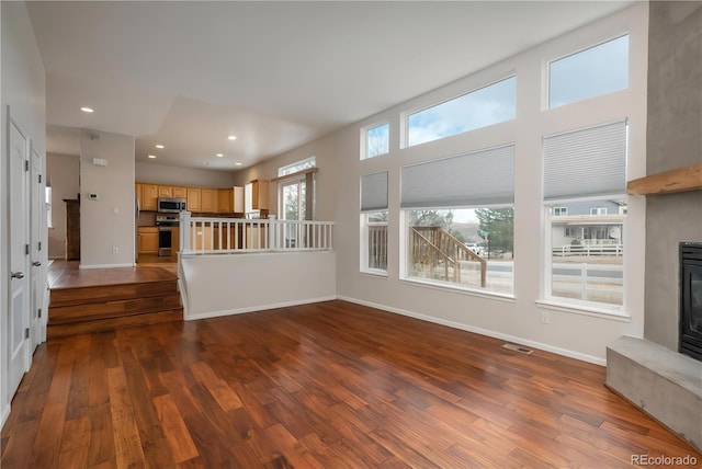 unfurnished living room with visible vents, dark wood-style flooring, baseboards, and recessed lighting