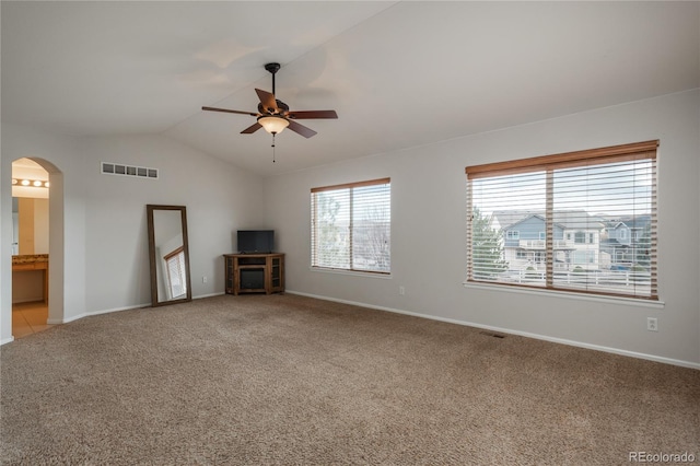 unfurnished living room with a ceiling fan, lofted ceiling, visible vents, arched walkways, and light carpet