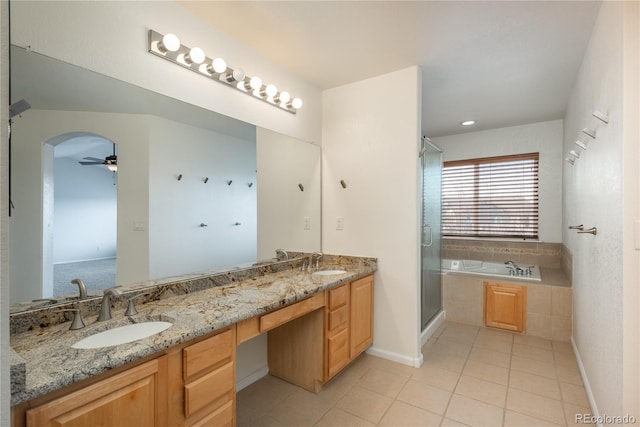 bathroom with a sink, tile patterned flooring, double vanity, and a garden tub