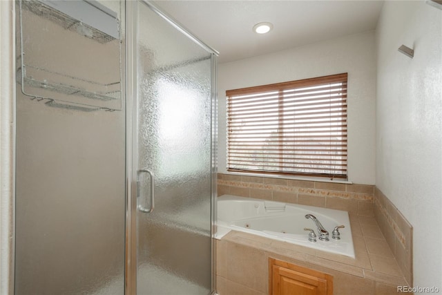full bathroom featuring a whirlpool tub and a shower stall