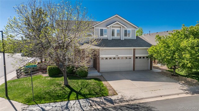 7506 Chipmunk Pl, Littleton, CO 80125 - view of front facade with driveway, brick siding, a garage, a shingled roof, and a front lawn