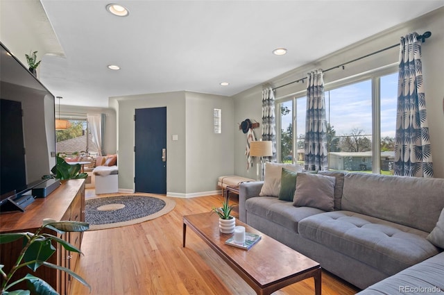 living area featuring light wood-style floors, baseboards, and recessed lighting