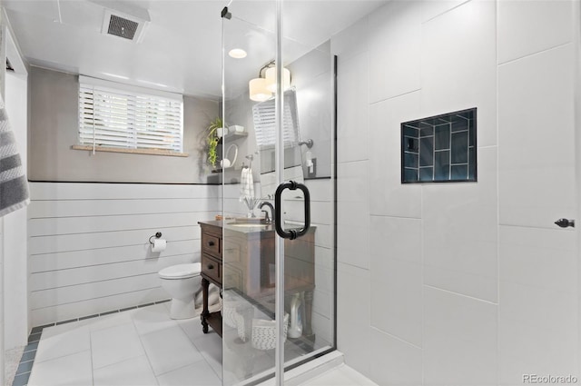 bathroom with visible vents, vanity, tile patterned floors, toilet, and tiled shower