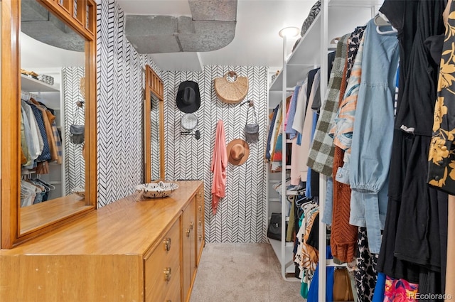 walk in closet featuring light colored carpet