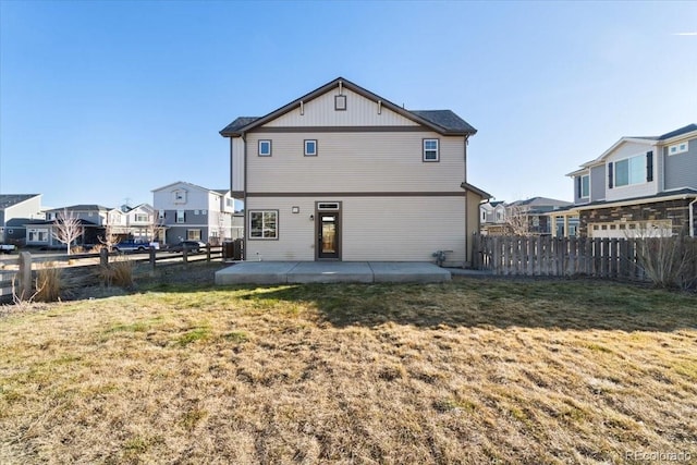 back of house with a yard, a patio area, fence, and a residential view