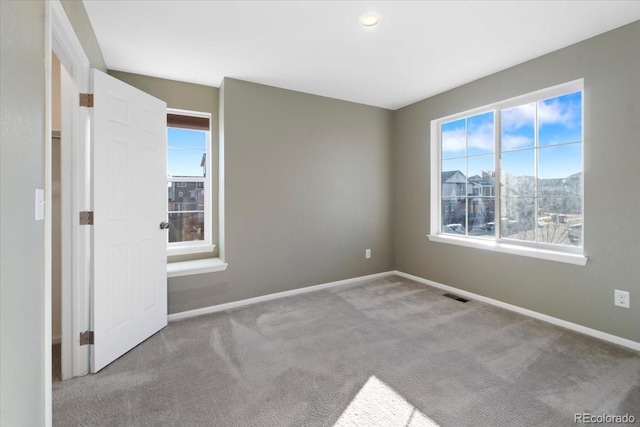 unfurnished bedroom featuring carpet, visible vents, and baseboards