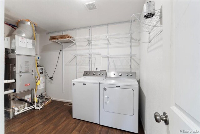 laundry area featuring visible vents, laundry area, washing machine and clothes dryer, and dark wood finished floors