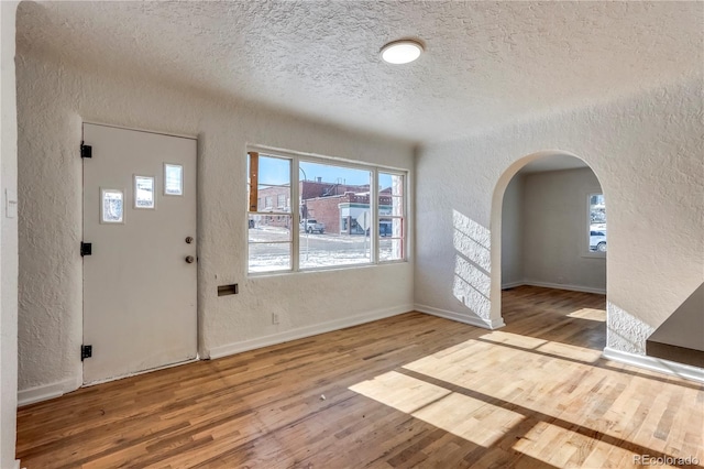 foyer entrance featuring wood-type flooring and a textured ceiling