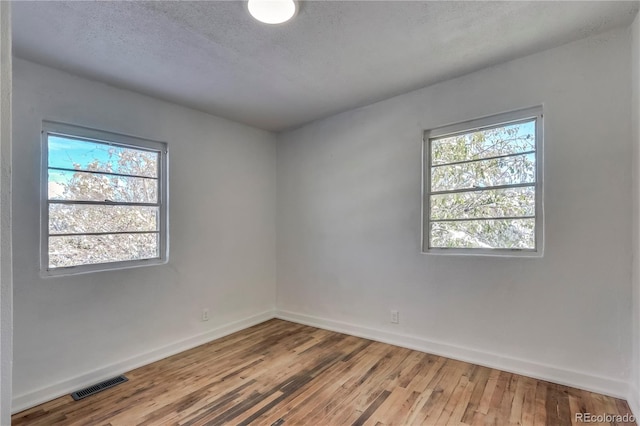 empty room featuring hardwood / wood-style floors and a textured ceiling