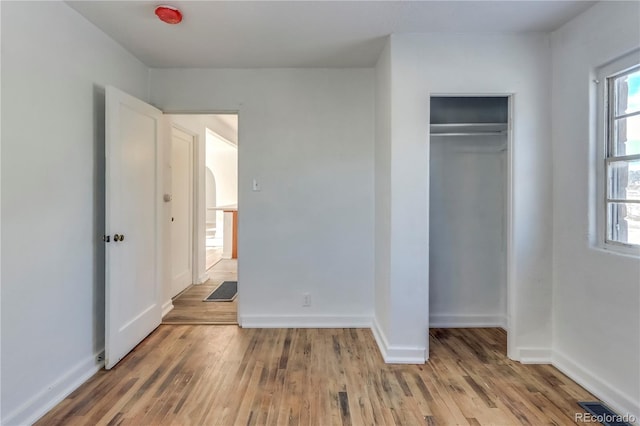 unfurnished bedroom with wood-type flooring and a closet