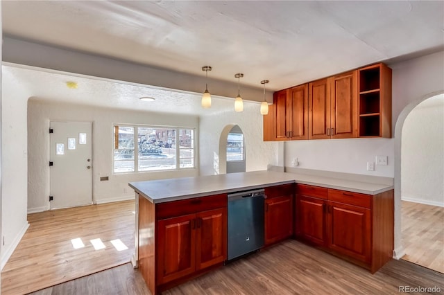 kitchen with stainless steel dishwasher, hanging light fixtures, light hardwood / wood-style flooring, and kitchen peninsula