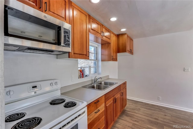 kitchen featuring hardwood / wood-style flooring, sink, and white range with electric stovetop