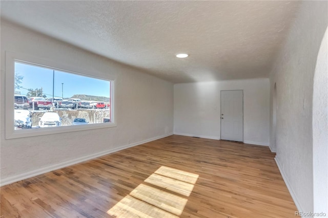 empty room featuring light hardwood / wood-style floors and a textured ceiling