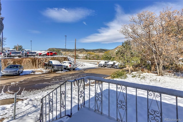 snow covered back of property with a mountain view