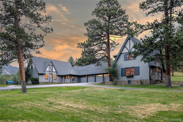 view of front of home featuring a yard, an attached garage, and driveway