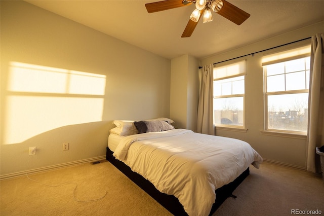 bedroom featuring light carpet, visible vents, baseboards, and a ceiling fan