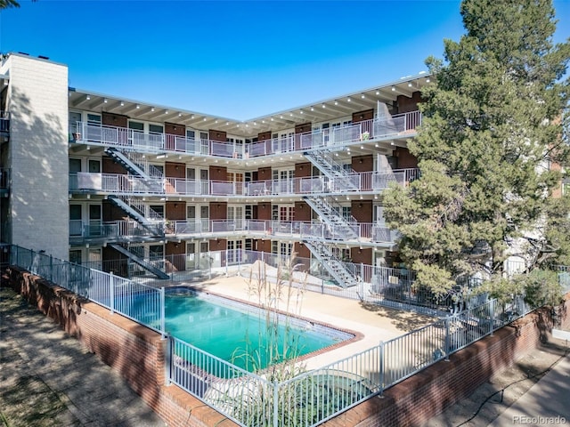 community pool featuring a patio and fence