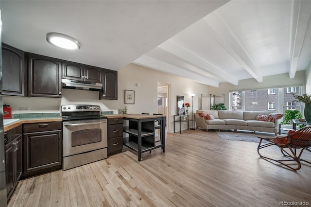 kitchen featuring beam ceiling, under cabinet range hood, stainless steel range with electric cooktop, light wood-style floors, and dark brown cabinets