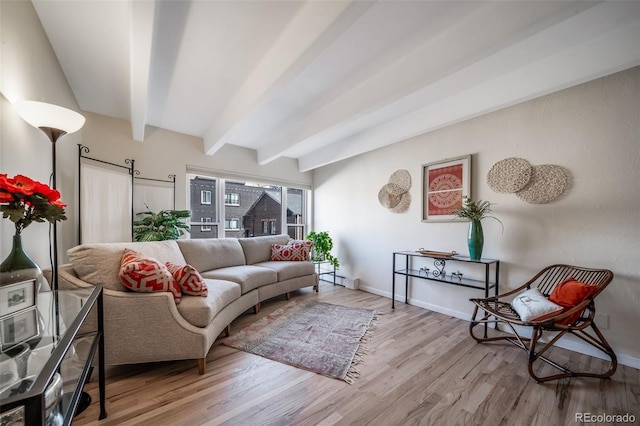 living room featuring beamed ceiling, baseboards, and wood finished floors