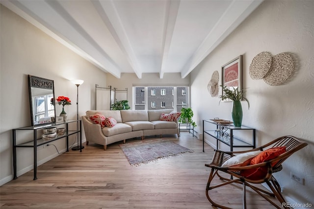 living room with beamed ceiling, baseboards, and wood finished floors